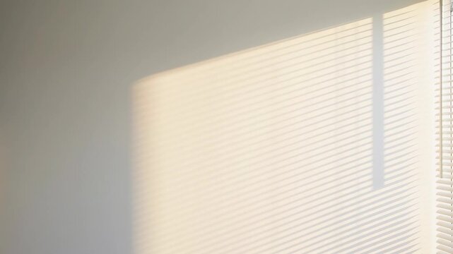 Time lapse of moving window blind shadows on a wall as sunlight shifts