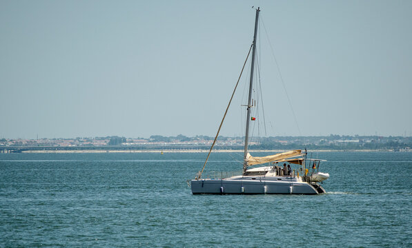 Sailing Yacht on Calm Coastal Waters with Cityscape Background