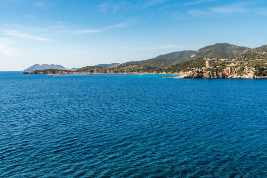 Landscape of the coast of Teulada in southern Sardinia, Italy, featuring Porto di Teulada and the historic Torre del Budello in the background.