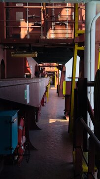 Industrial metallic walkway underneath heavy freight containers on a commercial ocean cargo ship