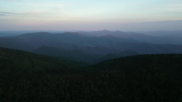 Drone aerial view of Roan Mountain during blue hour, revealing the layered silhouettes of the Blue Ridge Mountains beneath the fading evening sky