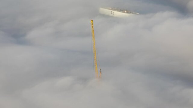 mist of clouds below the skyline of dubai with only construction cranes showing