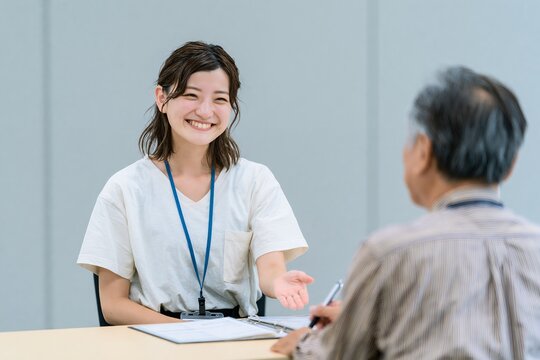 笑顔で高齢者と対話する若い女性の親身なビジネス相談