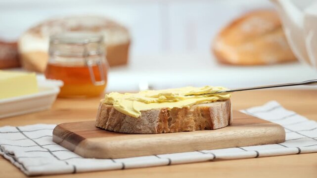 Butter spreading on fresh bread slice, close up homemade breakfast scene, copy space