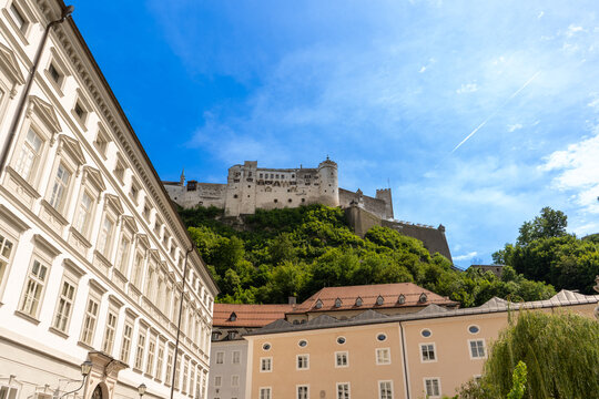 Hohensalzburg Fortress on Hill with Kapitelplatz Buildings and Blue Sky View in Salzburg Austria.