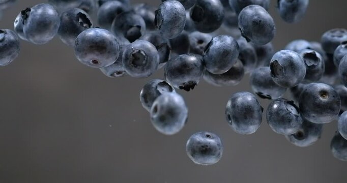 Blueberries falling in super slow motion on black background
