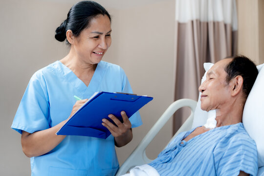 Professional nurse recording patient information while caring for a senior man in a hospital room representing compassionate healthcare recovery and quality medical service.
