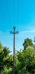 Obraz premium Wooden utility pole with overhead power lines in rural northern Italy