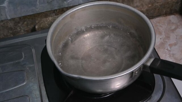 Boiling Water in a Pot on a Kitchen Stove Burner Close Up