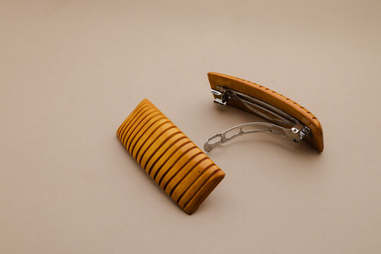 Elegant pair of wooden hair barrettes with a ribbed design showcase natural beauty and simple sophistication on a neutral background