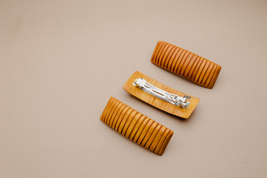 Elegant wooden barrettes arrange on a neutral background, highlight a blend of natural texture and classic hair accessory design for beauty and style