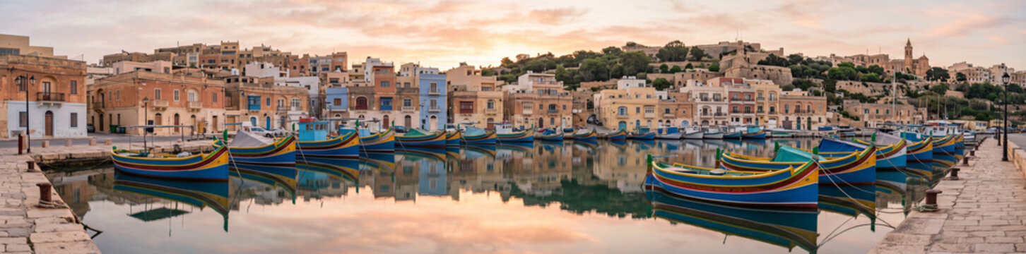 Barques traditionnelles luzzu align&eacute;es dans le port de p&ecirc;che au lever du soleil