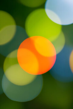 Abstract Colorful Bokeh Background Featuring Vibrant Orange, Lime Green, and Soft Blue Circles of Light, Perfect for Artistic Digital Designs, Holiday Celebrations, and Elegant Festive