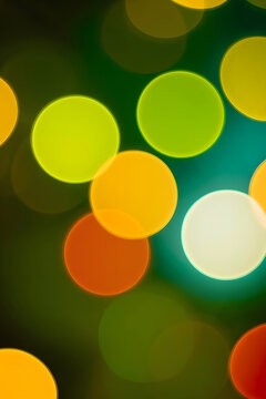 Abstract Background with Vibrant Multicolored Bokeh Circles, Soft Glowing Light Orbs in Yellow, Orange and Green Tones, Festive Holiday Atmosphere, Decorative Texture for Digital Graphic