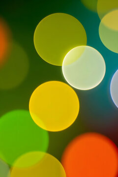 Abstract Colorful Bokeh Background Featuring Vibrant Yellow, Orange, and Green Light Orbs on a Dark Backdrop, Perfect for Modern Digital Designs, Festive Celebrations, and Artistic Textures