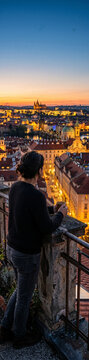 Personne admirant le coucher de soleil sur une vieille ville illumin&eacute;e