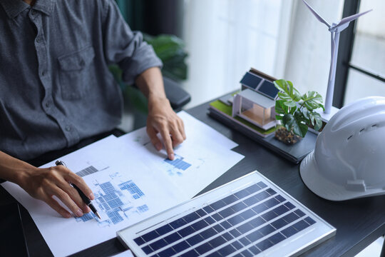 Engineer Working on Solar Panel Design and System Planning on Desk.