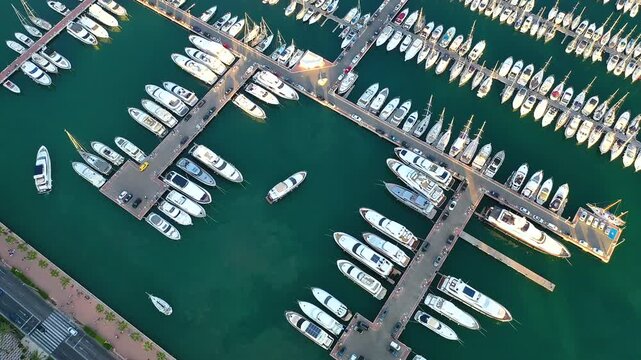 Aerial view of a yacht entering in Marina Alicante, Spain, with others moorings in the Mediterranean Sea.