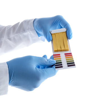 Laboratory worker with PH test strips and color table isolated on white, closeup