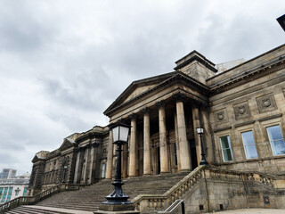Obraz premium Historic neoclassical Central Library building with grand steps and tall columns in Liverpool, UK under a moody cloudy sky