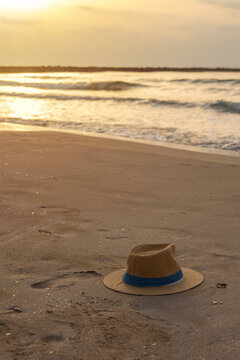 Vertical panama hat and footprint on quiet beach