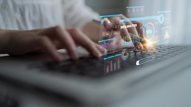 Close-Up of a Person Using a Laptop with Overlay of Data Analytics Visuals and Graphs in a Modern Workspace Environment Sigmoid