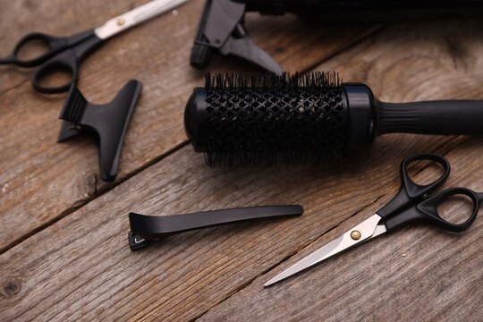 Different hairdresser's tools on wooden table, closeup