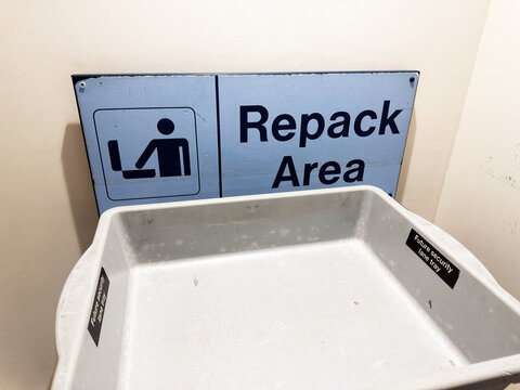 Repack area security tray at Manchester airport baggage screening and repacking station with empty plastic bin
