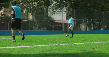 Fototapeta premium Friends playing informal soccer match on neighborhood field, casually competing for ball near goal, concept of teamwork, recreation, and friendship in community sports