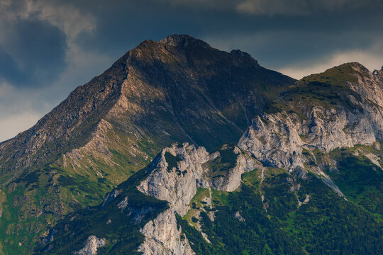 Sunlit green mountain valley with meadow, forested slopes in Zakopane Tatras mountains