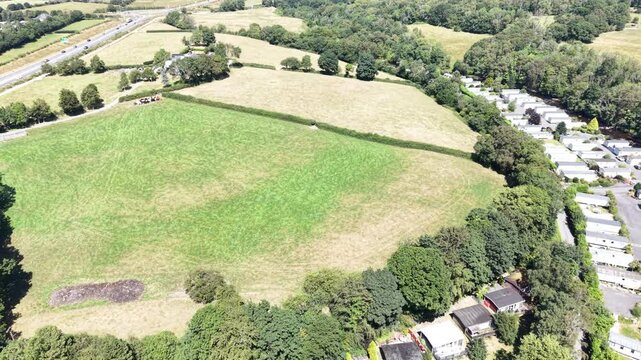 Aerial drone 4K clip showing caravans placed within open valley vegetation under warm natural tones Wales