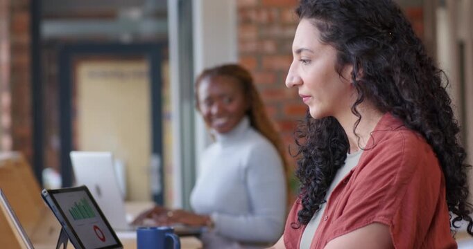 African American women team coral woman typing laptop at bar, tablet causing peer smiling, resuming