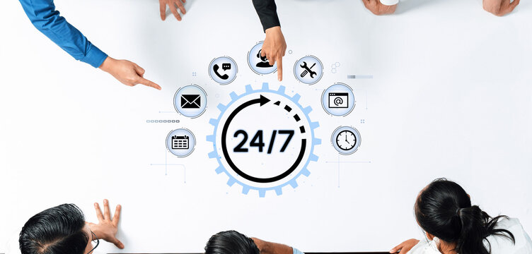 Business team collaboration concept with connectivity icons and 24-7 service clock on a desk representing continuous support and communication. Entropy.