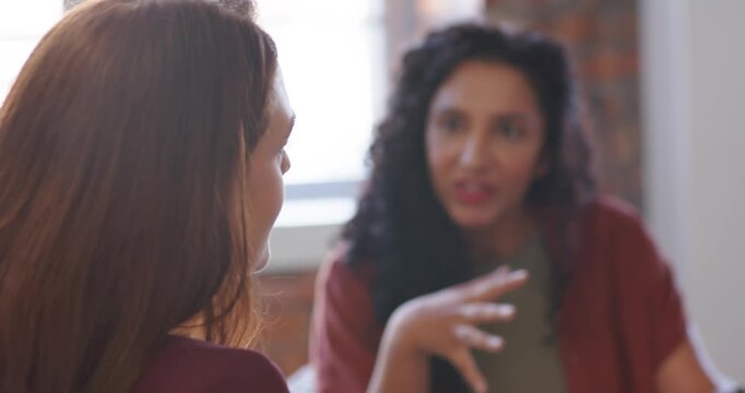 Women in office watching speaker gesturing causing braided woman reading tablet charts, copy space