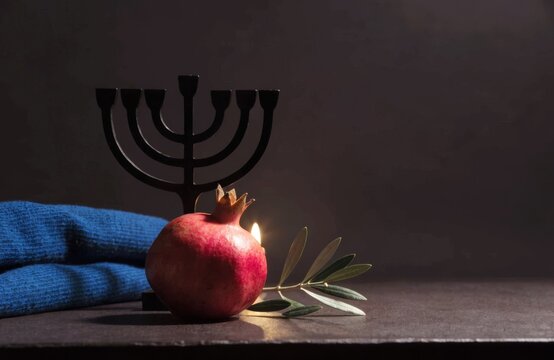 Elegant Jewish faith and heritage still life with pomegranate and menorah
