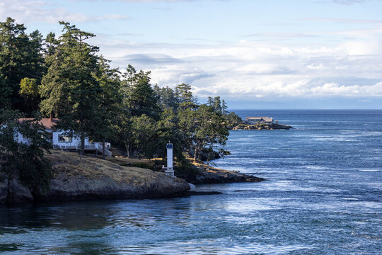 Coastal Cottage and Lighthouse on Forested Cliff Overlooking Ocean Near Galiano Island, British Columbia