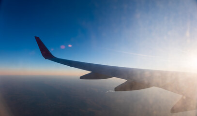 Fototapeta premium View on sunset and airplane wing from the inside