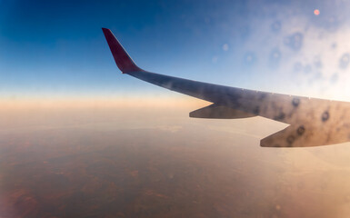Fototapeta premium View on sunset and airplane wing from the inside