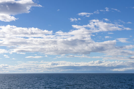 Calm Ocean Horizon With Blue Sky and Puffy Clouds Over the Strait of Georgia, British Columbia, Canada