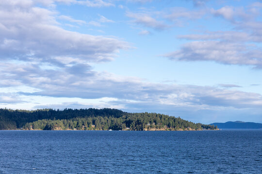Calm Ocean and Forested Gulf Islands Landscape Under Blue Sky in British Columbia, Canada