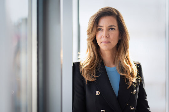Portrait of an executive business woman standing by a window in a modern office