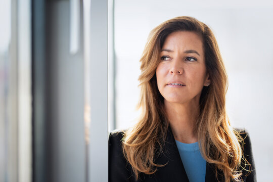 Portrait of an executive business woman standing by a window in a modern office