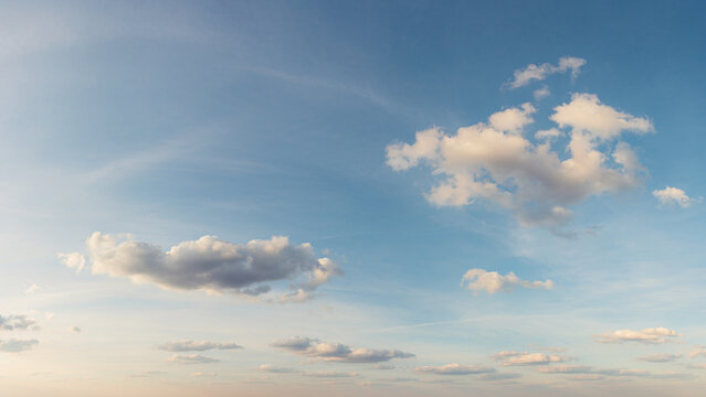 Wide panoramic view of vibrant blue sky filled with fluffy white cumulus and cirrus clouds