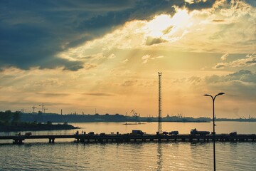 Fototapeta premium Dramatic Sunset and Sun Rays over Tallinn Port Pier Silhouette