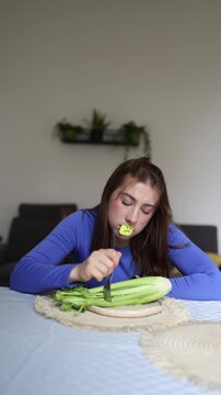 Vertical screen Young woman with anorexia struggles to eat plain celery illustrating how eating disorders are serious mental health conditions not only physical nutrition problems