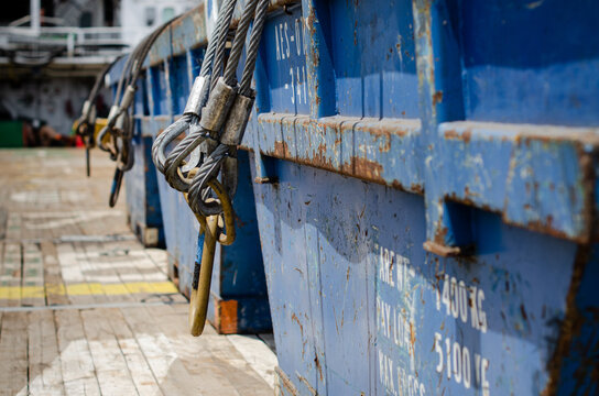 Cargo skips secured on the main cargo deck of an offshore support vessel. The cargo skips are fitted with lifting slings and shackles for safe handling by offshore cranes during the transportation