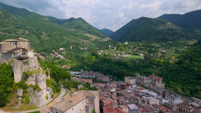 Subiaco Italy Aerial Drone Flight Over Medieval Town Rocca dei Borgia Castle with Clock Tower to Santa Scolastica Monastery in Mountain Distance Summer Travel Video 4K UHD