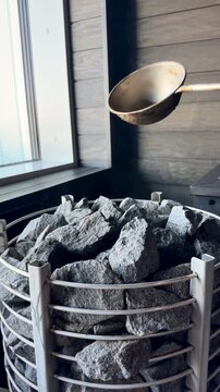 Throwing Water on Hot Sauna Stones with Ladle in Slow Motion