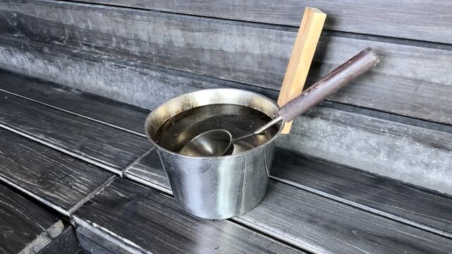 Steel Sauna Bucket and Ladle on Dark Wooden Bench B-Roll