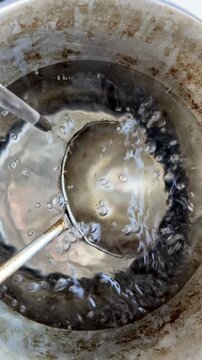 Water Pouring into Sauna Bucket with Ladle in Slow Motion